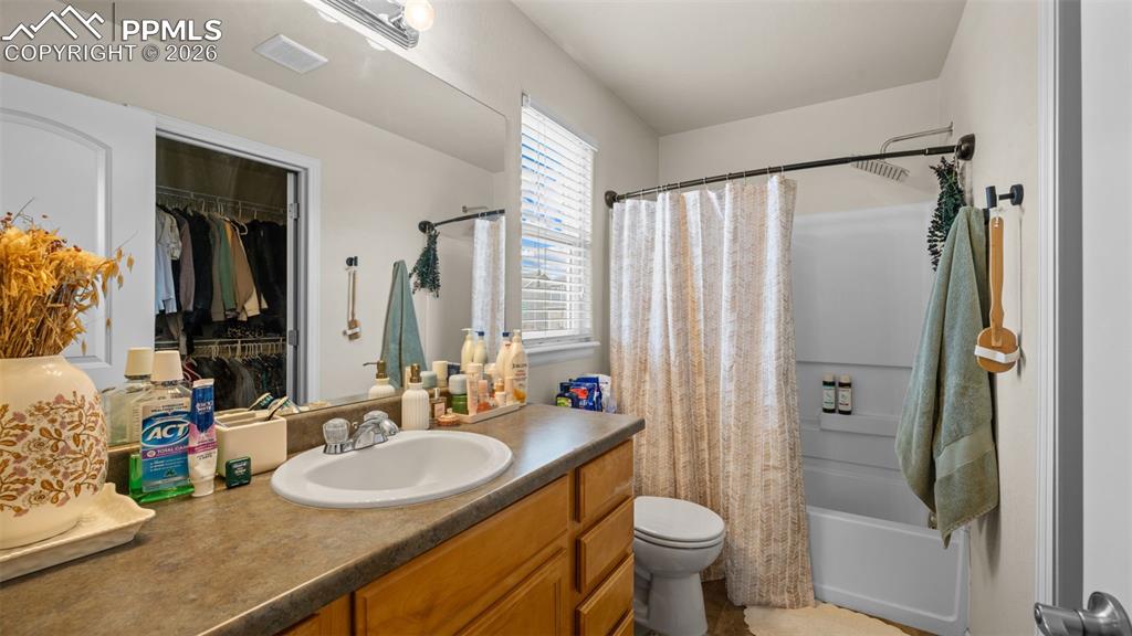Image 21 of 28: Full bath featuring vanity, shower / tub combo with curtain, and a walk in 