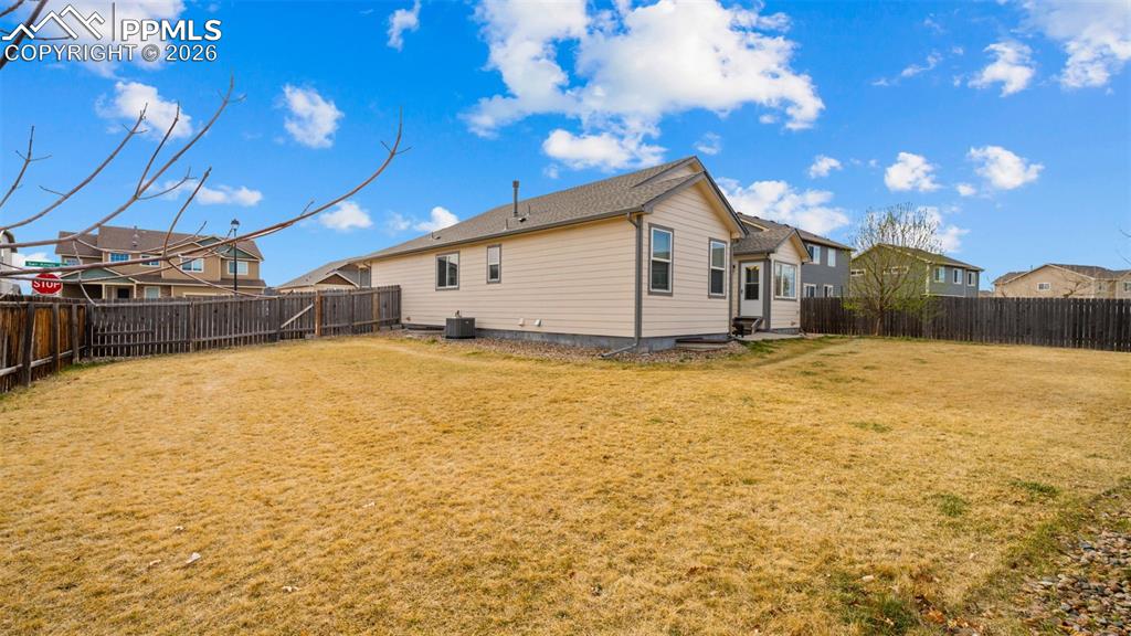 Image 25 of 28: Rear view of house with a fenced backyard and a residential view
