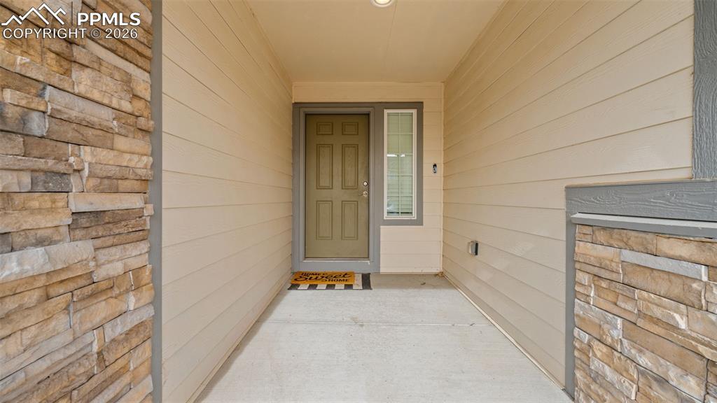 Image 4 of 28: Property entrance featuring stone siding and a porch