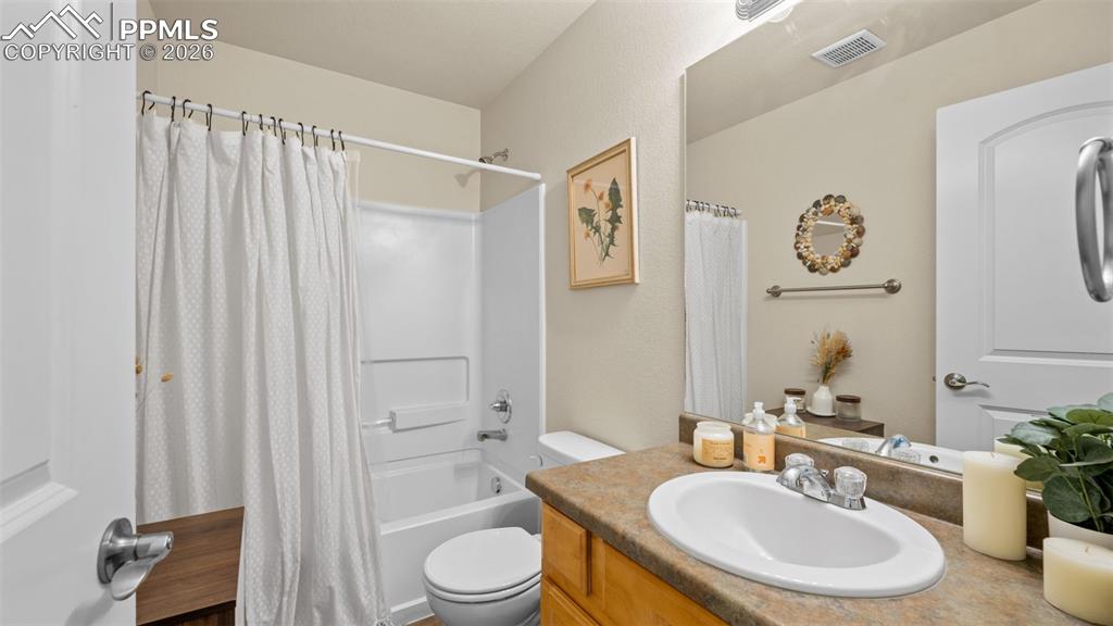 Image 6 of 28: Bathroom featuring vanity and shower / tub combo with curtain