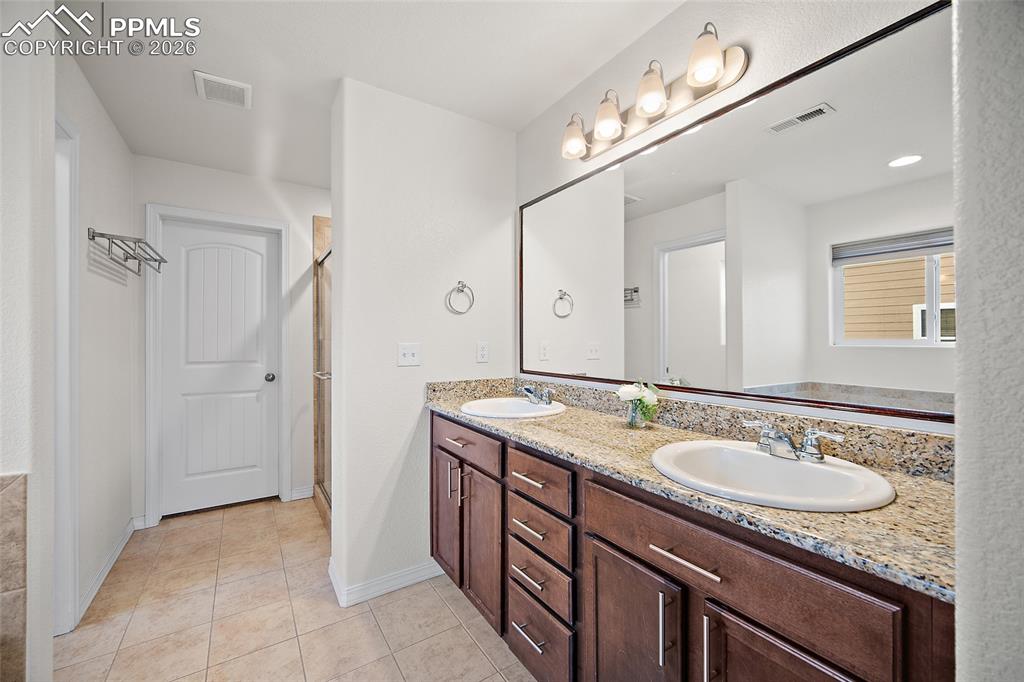 Image 26 of 37: Primary bathroom with double sinks. 