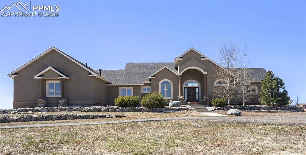 Caption: View of front of home with stucco siding and roof with shingles