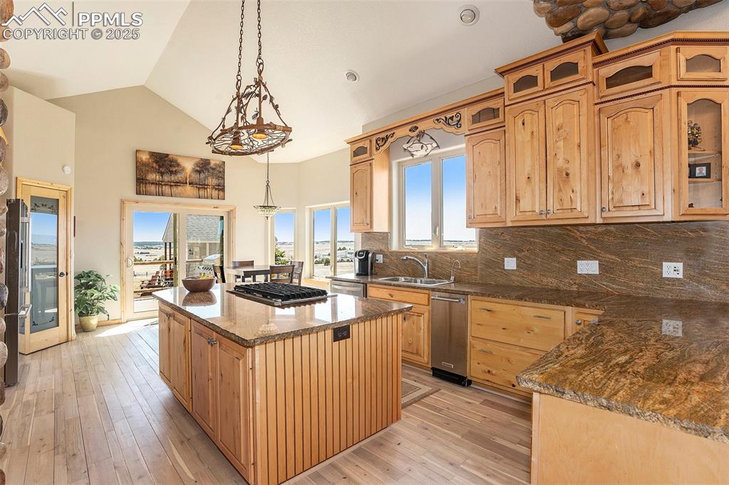 Image 11 of 47: Kitchen with decorative backsplash, glass insert cabinets, decorative light
