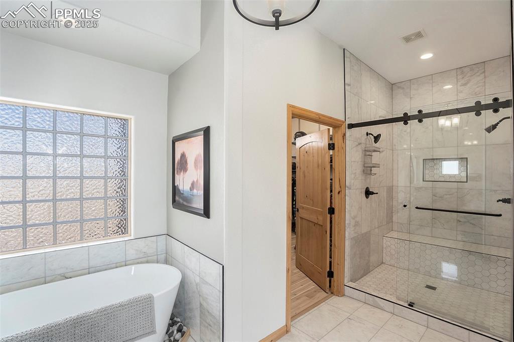 Image 17 of 47: Full bath with a shower stall, a freestanding tub, recessed lighting, tile