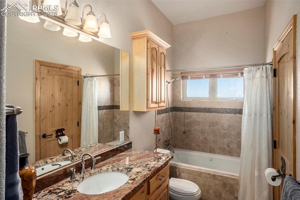Image 19 of 47: Bathroom with tiled shower / bath and vanity