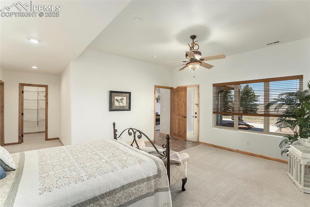 Image 23 of 47: Bedroom featuring light colored carpet, a spacious closet, and ceiling fan