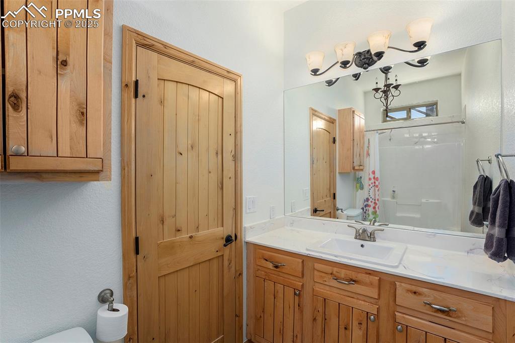 Image 26 of 47: Bathroom featuring vanity, a textured wall, and a shower with curtain
