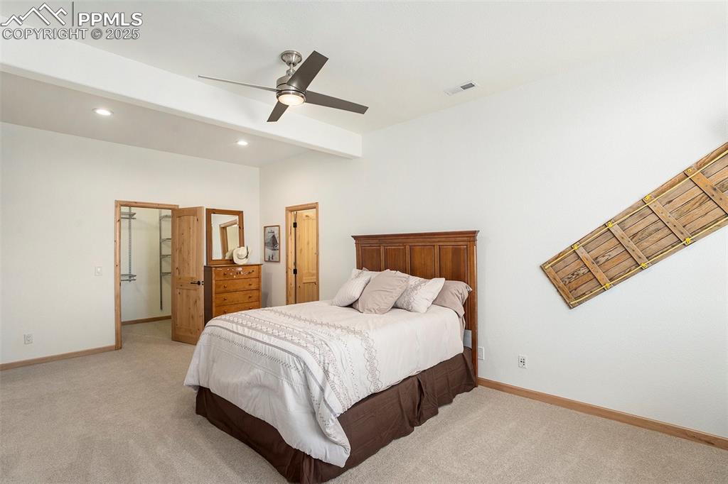 Image 28 of 47: Bedroom with beamed ceiling, light carpet, ceiling fan, and recessed lighti