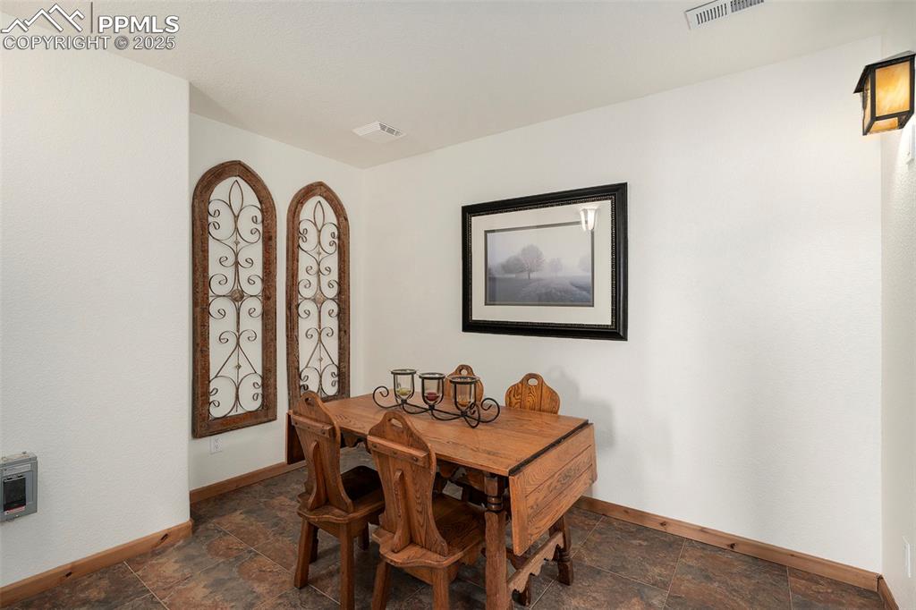 Image 31 of 47: Dining space featuring dark stone finish floors and heating unit