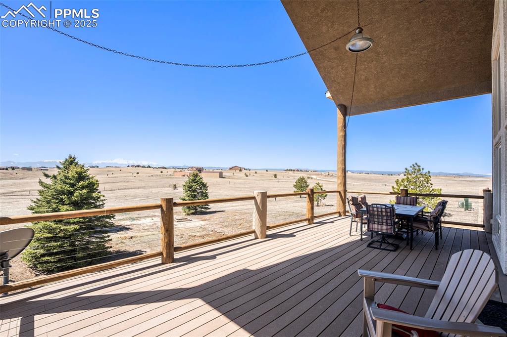 Image 33 of 47: Wooden deck featuring outdoor dining space and a view of rural / pastoral a