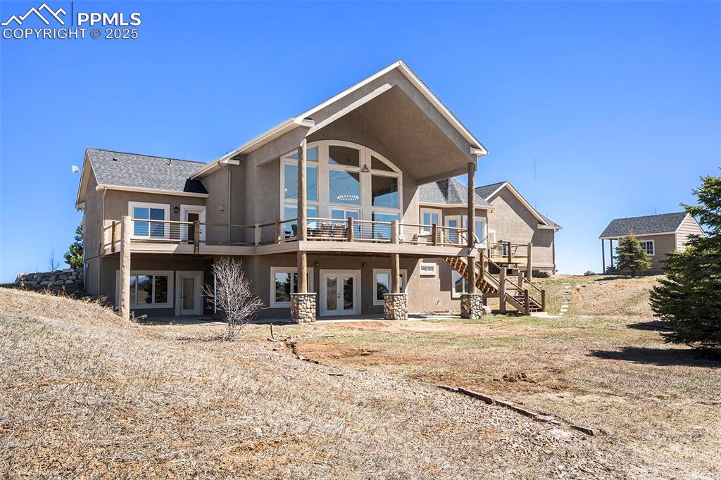 Image 37 of 47: Rear view of property with a patio area, stucco siding, stairs, a wooden de
