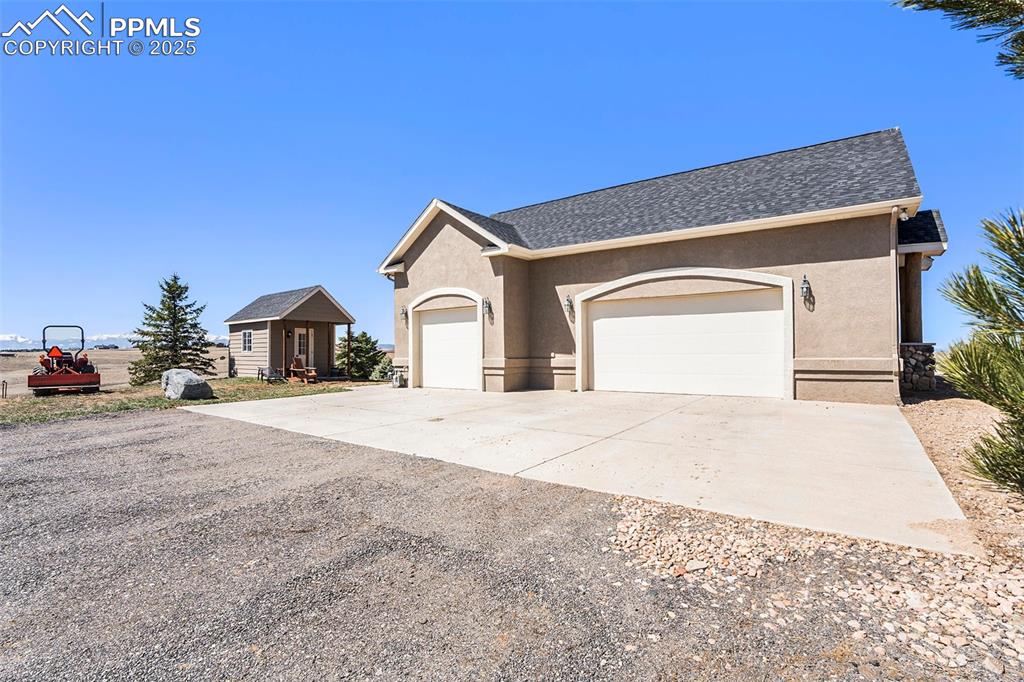 Image 38 of 47: View of front facade with concrete driveway, stucco siding, a garage, and r