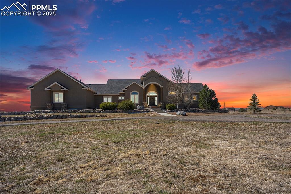 Image 42 of 47: Ranch-style home with stucco siding and a yard