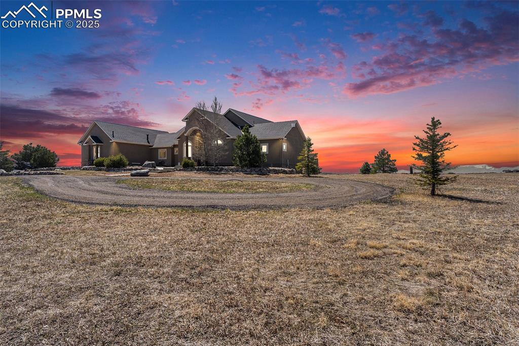 Image 43 of 47: View of front of property featuring curved driveway and a yard