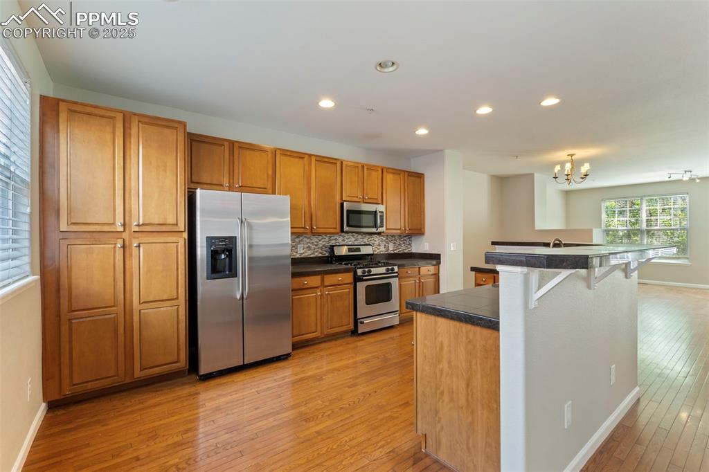 Image 14 of 48: Kitchen featuring appliances with stainless steel finishes, light wood-styl