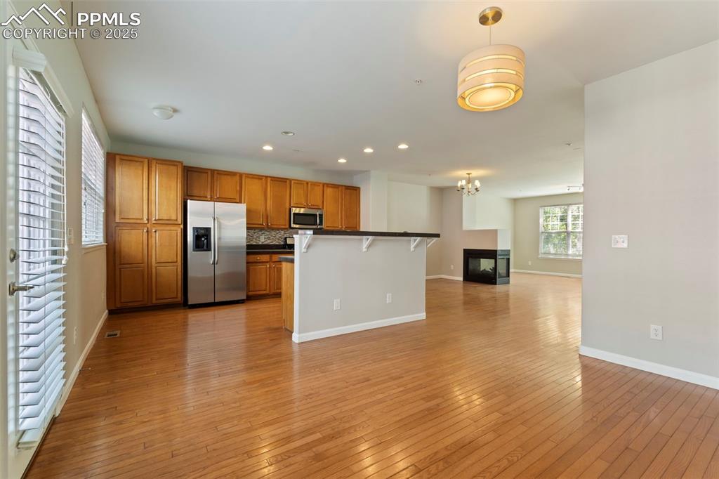 Image 17 of 48: Kitchen with open floor plan, stainless steel appliances, dark countertops,