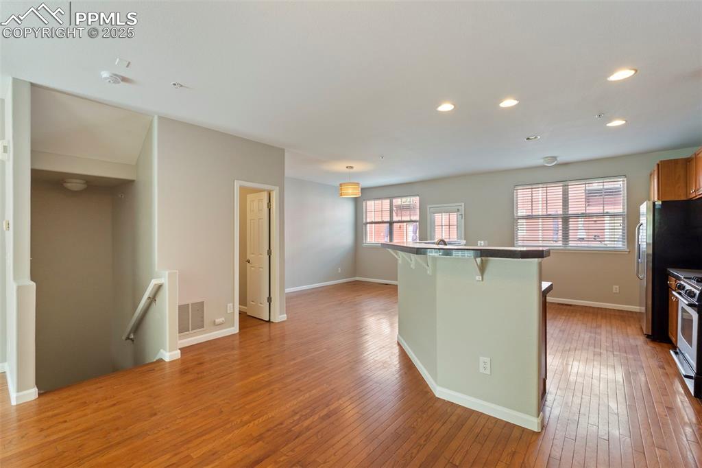 Image 19 of 48: Kitchen featuring a breakfast bar area, light wood finished floors, recesse