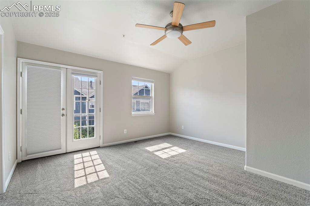 Image 22 of 48: Spare room featuring carpet floors, ceiling fan, and vaulted ceiling