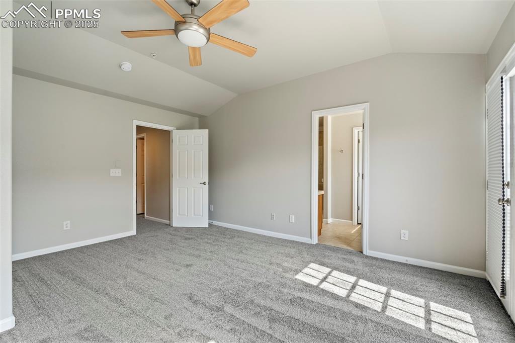 Image 24 of 48: Unfurnished bedroom featuring lofted ceiling, carpet floors, and ceiling fa