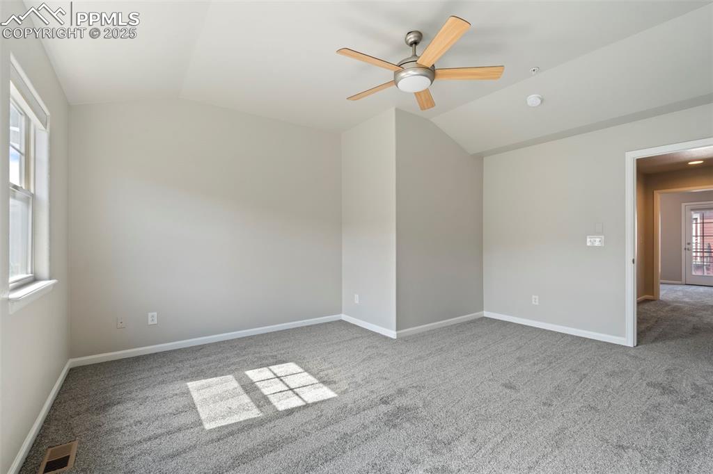 Image 25 of 48: Carpeted empty room with lofted ceiling and a ceiling fan