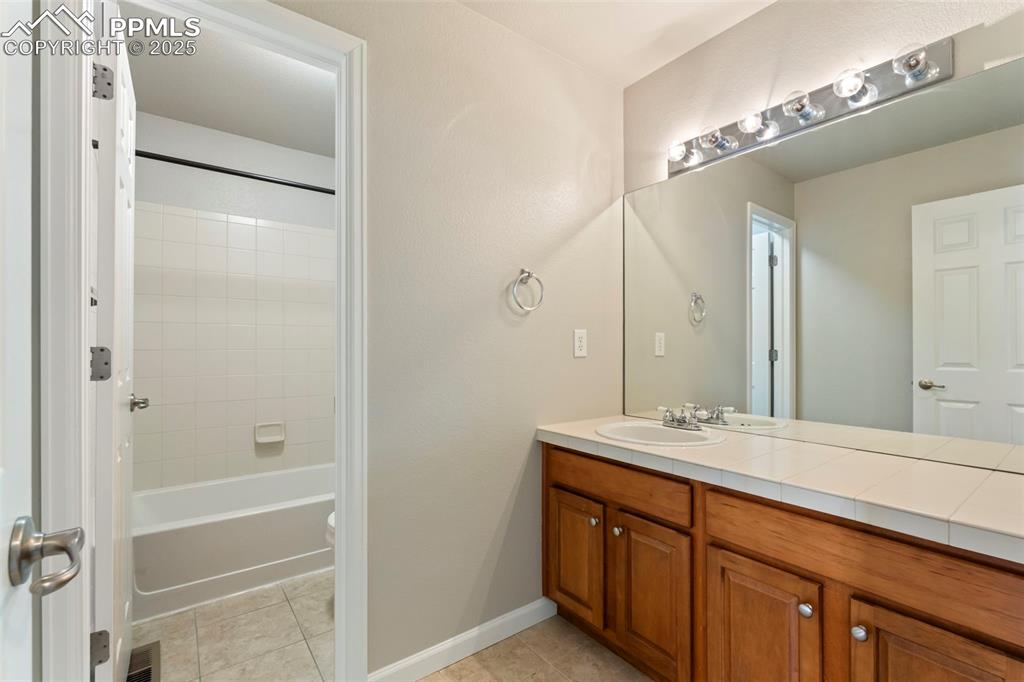 Image 31 of 48: Full bath featuring vanity, tile patterned flooring, and tub / shower combi