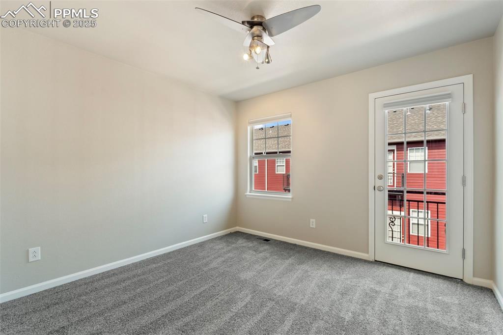Image 33 of 48: Carpeted spare room with ceiling fan and baseboards