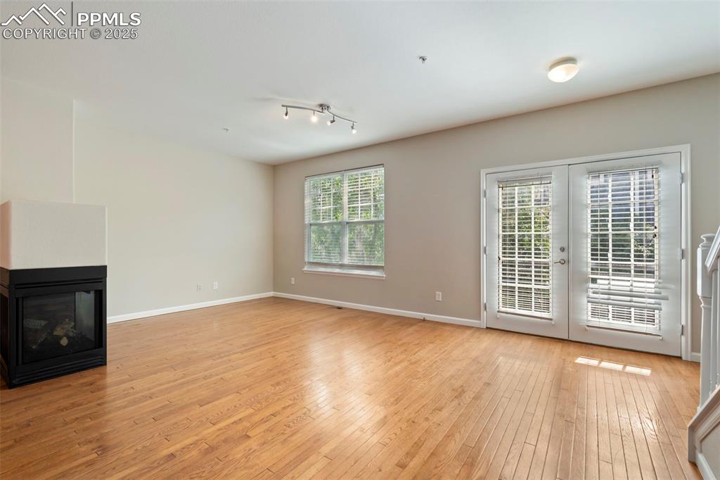 Image 5 of 48: Unfurnished living room with light wood finished floors and a multi sided f