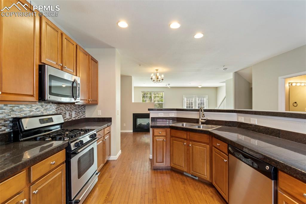 Image 9 of 48: Kitchen featuring appliances with stainless steel finishes, a chandelier, t