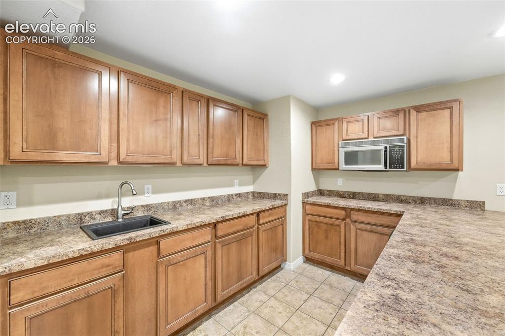 Image 31 of 47: Kitchenette with Large Counter Bar and Abundant Cabinetry