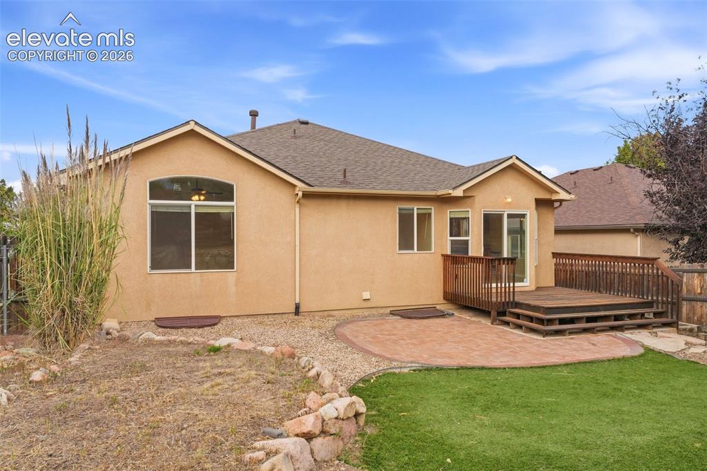 Image 44 of 47: Backyard with Well-Appointed Flagstone Patio off Wood Deck