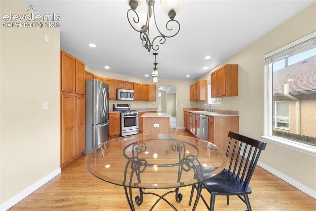 Image 9 of 47: Gleaming Hardwood Flooring through Kitchen and Dining Area