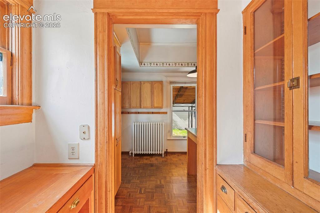 Image 10 of 31: Built-in desk and secretary cabinet leading to the kitchen