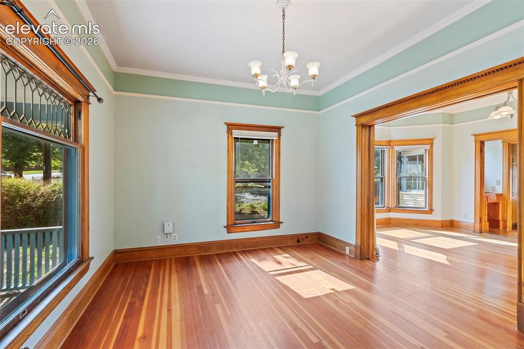 Image 6 of 31: Main level living room with beautiful original window ,woodwork, and pocket