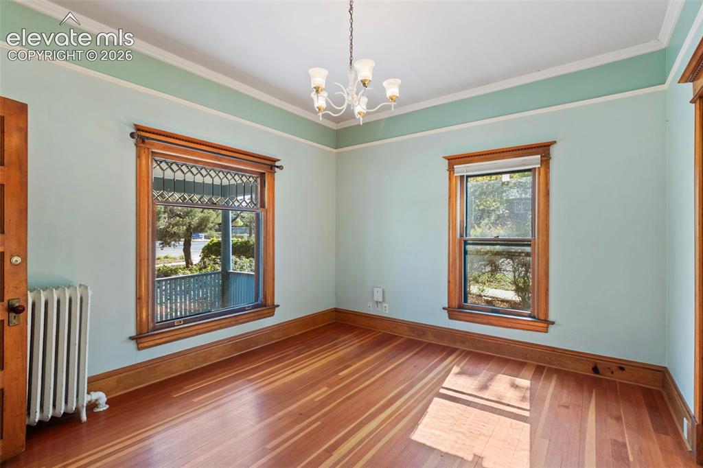 Image 7 of 31: Main level living room featuring beautiful wood work and original window.