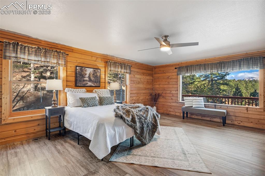 Image 13 of 41: Main level primary bedroom with large picture windows 