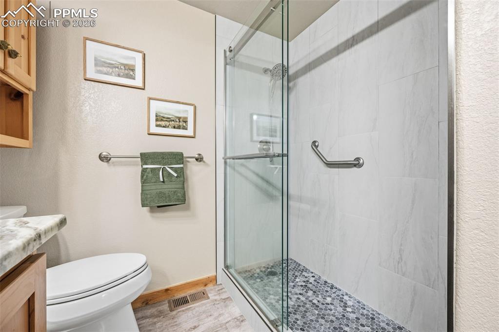 Image 18 of 41: Main level primary bathroom with newly updated shower