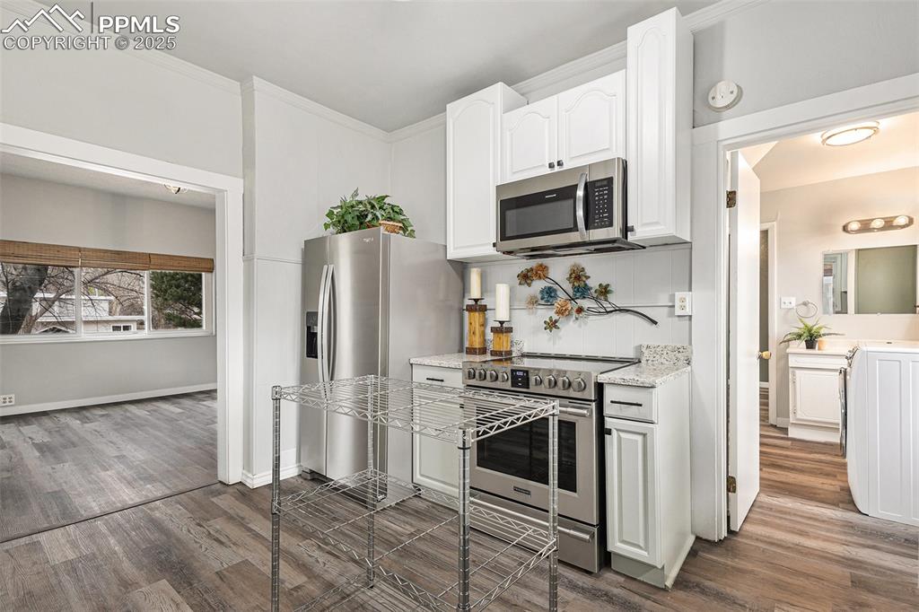 Image 7 of 37: Kitchen with LVP flooring, granite counters and brand new stainless steel a