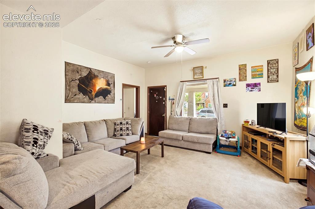 Image 13 of 26: Textured carpeting throughout, a ceiling fan with integrated lighting, and