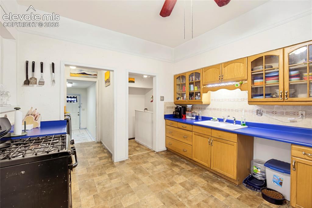 Image 16 of 26: Kitchen featuring wood-finish cabinetry, a gas range, dual-basin sink, and