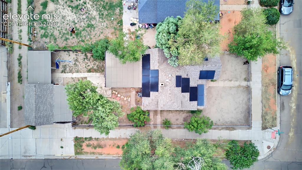 Image 4 of 26: Rooftop solar panels, surrounding mature trees, paved sidewalks, and a corn