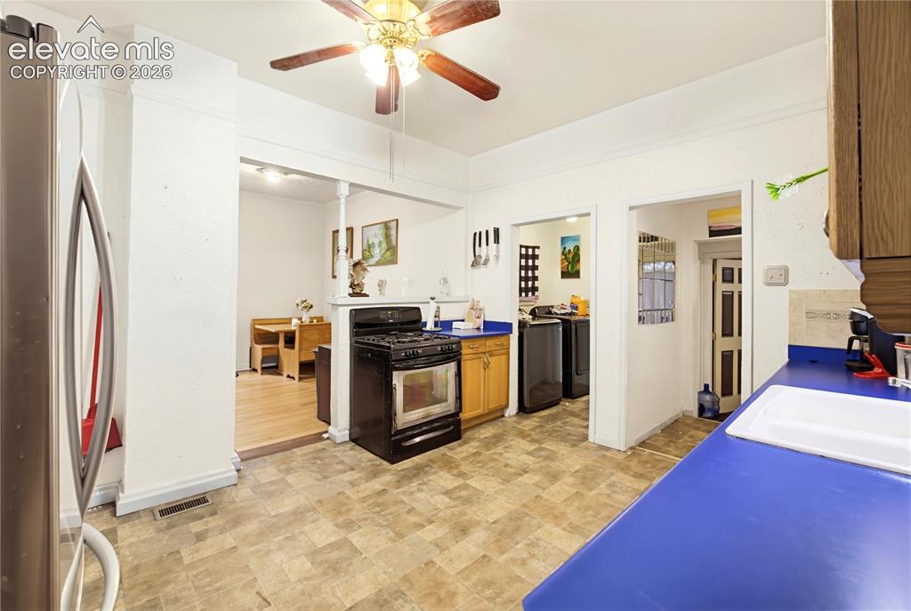 Image 9 of 26: Kitchen with patterned tile flooring, blue countertops, and wood-finish cab