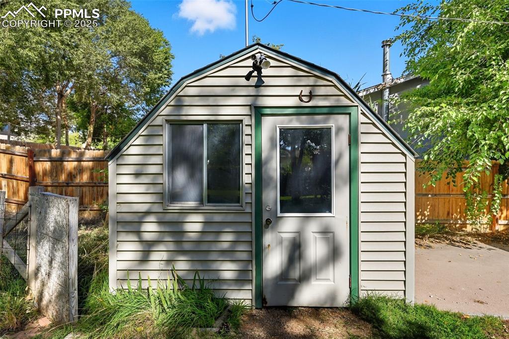 Image 21 of 29: View of outdoor shed featuring a flood light and electric outlets