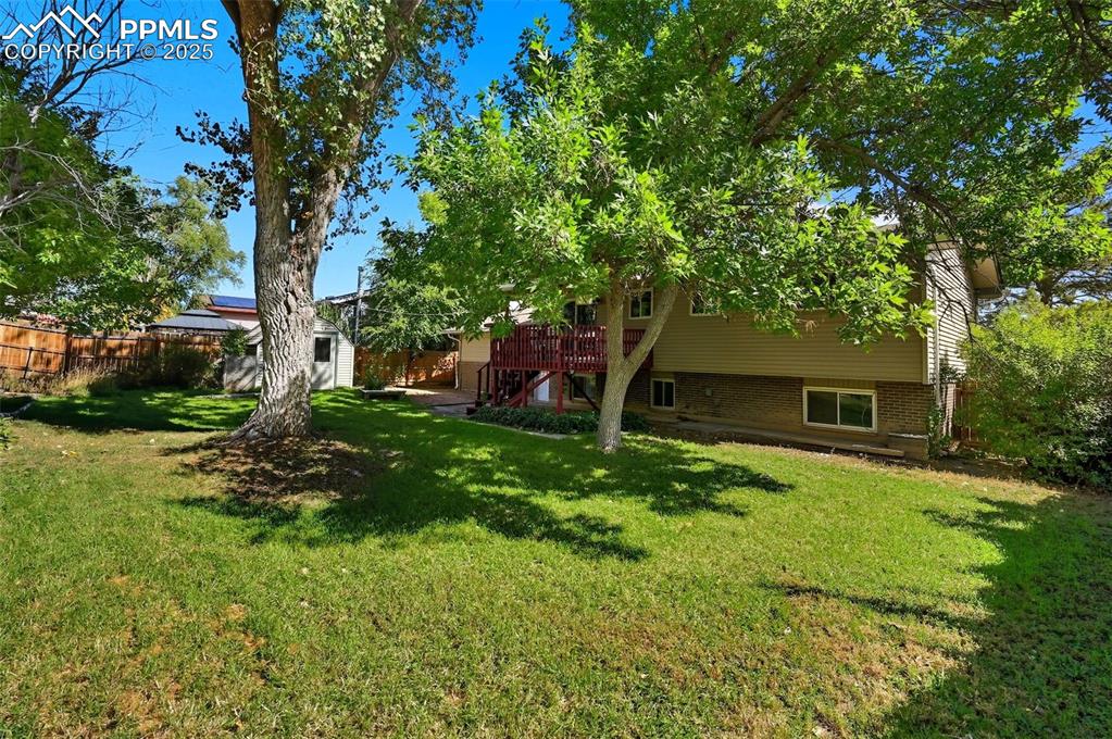 Image 25 of 29: View of yard featuring a wooden deck, an outbuilding, and stairway
