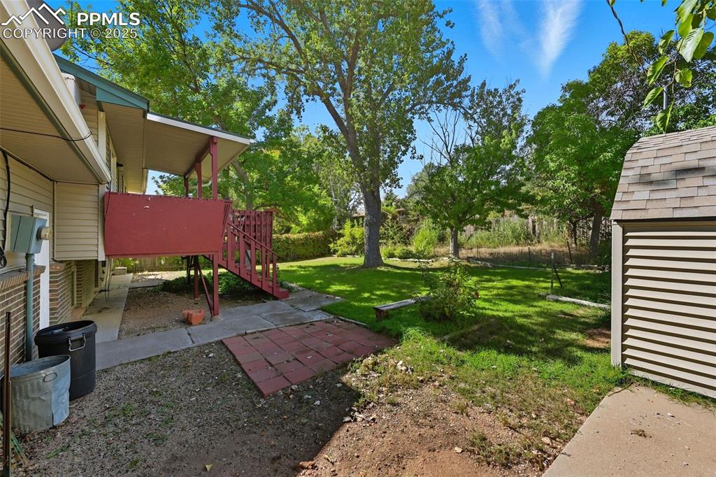 Image 27 of 29: View of grassy yard from the cement RV parking area