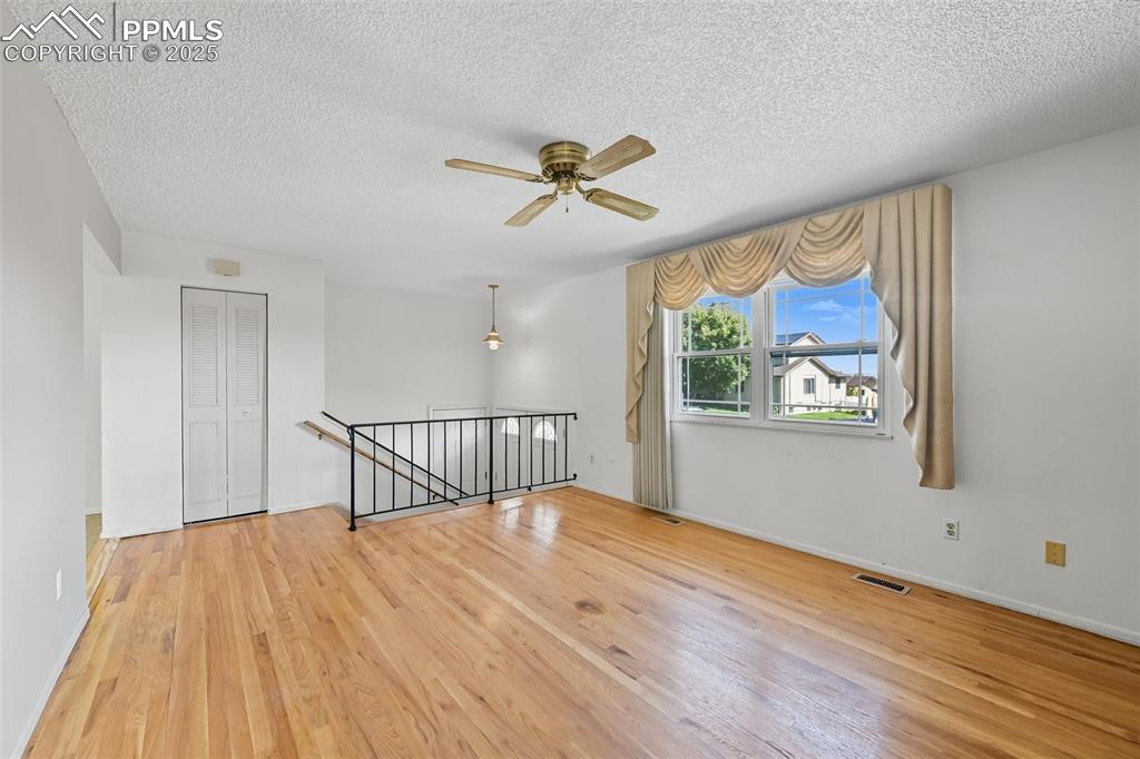 Image 3 of 29: Upper family room featuring a textured ceiling, light wood finished floors,