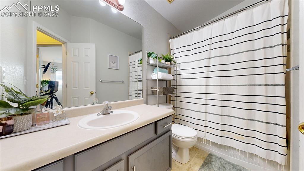 Image 21 of 37: Bathroom with vanity, a shower with curtain, tile patterned flooring, and l