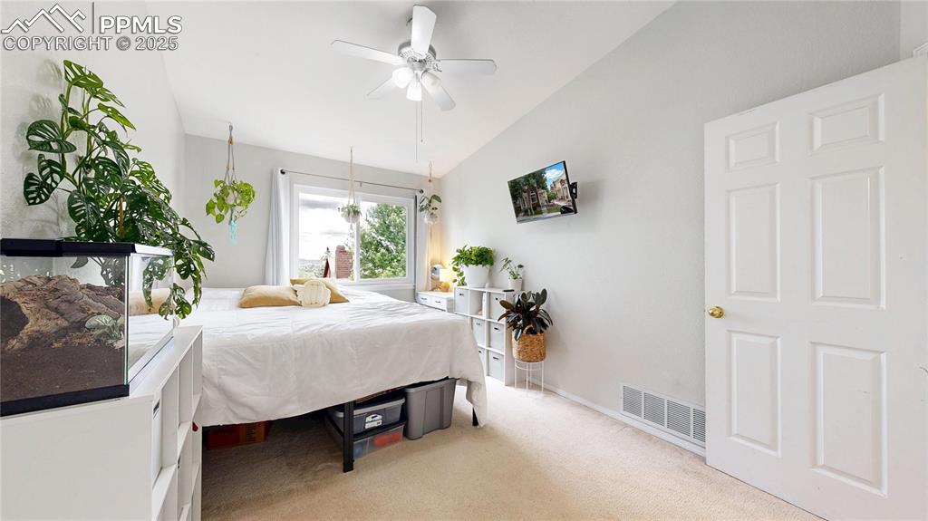 Image 23 of 37: Bedroom featuring vaulted ceiling, light carpet, and a ceiling fan