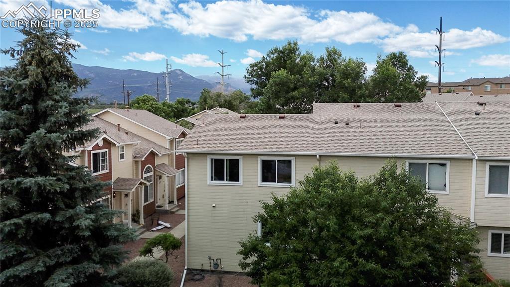 Image 34 of 37: View of side of home featuring a mountain view and roof with shingles
