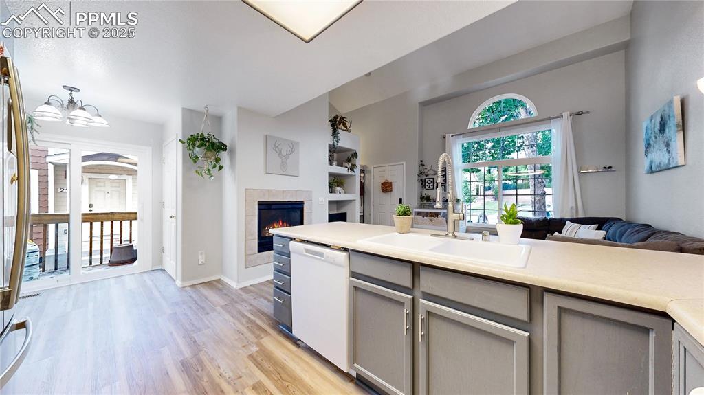 Image 9 of 37: Kitchen featuring dishwasher, open floor plan, light wood-style floors, a t