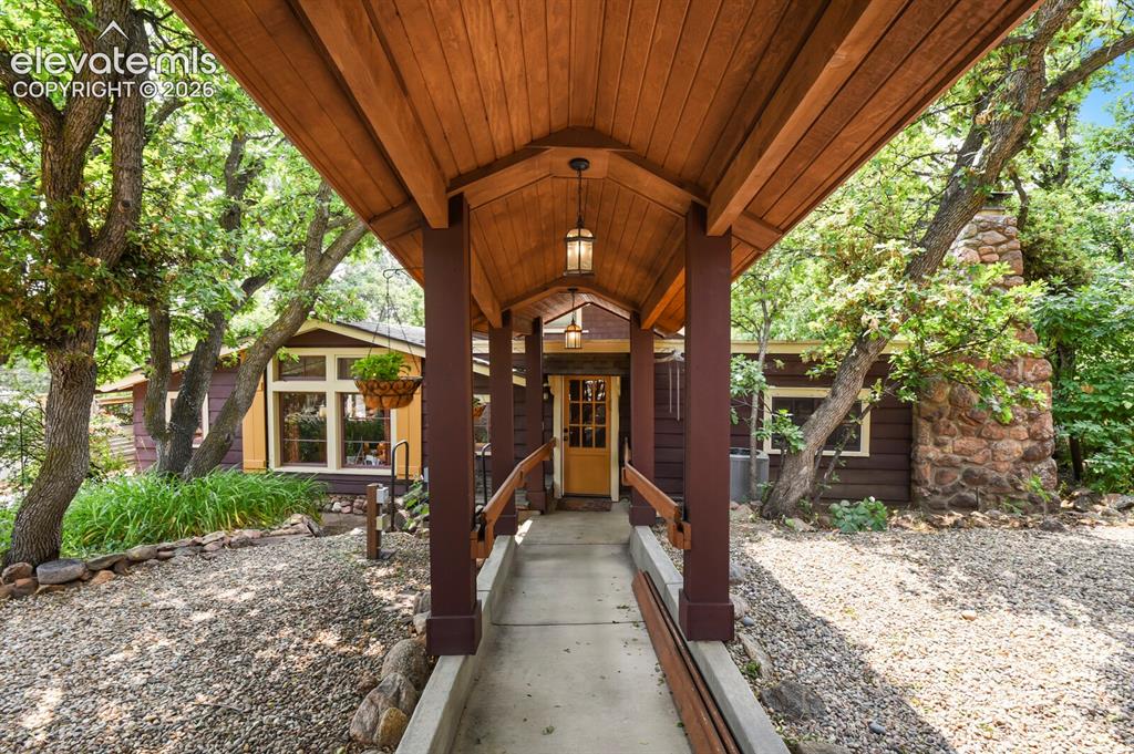 Image 3 of 50: Custom designed covered breezeway leading to the house from garage-wheelcha